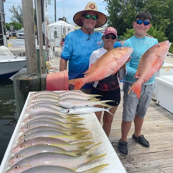 Dockside smiles and a table full of fish—nothing beats a successful day on the water.